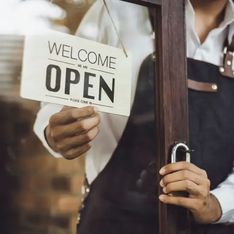 Man holding open sign for his small business